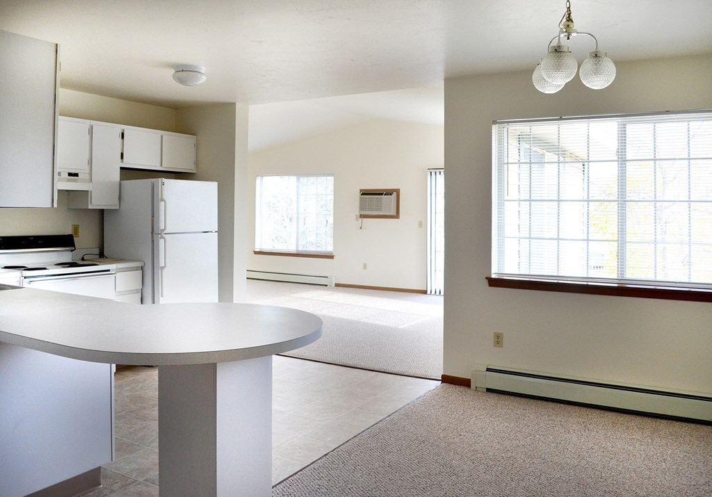 an empty kitchen and living room with a large window