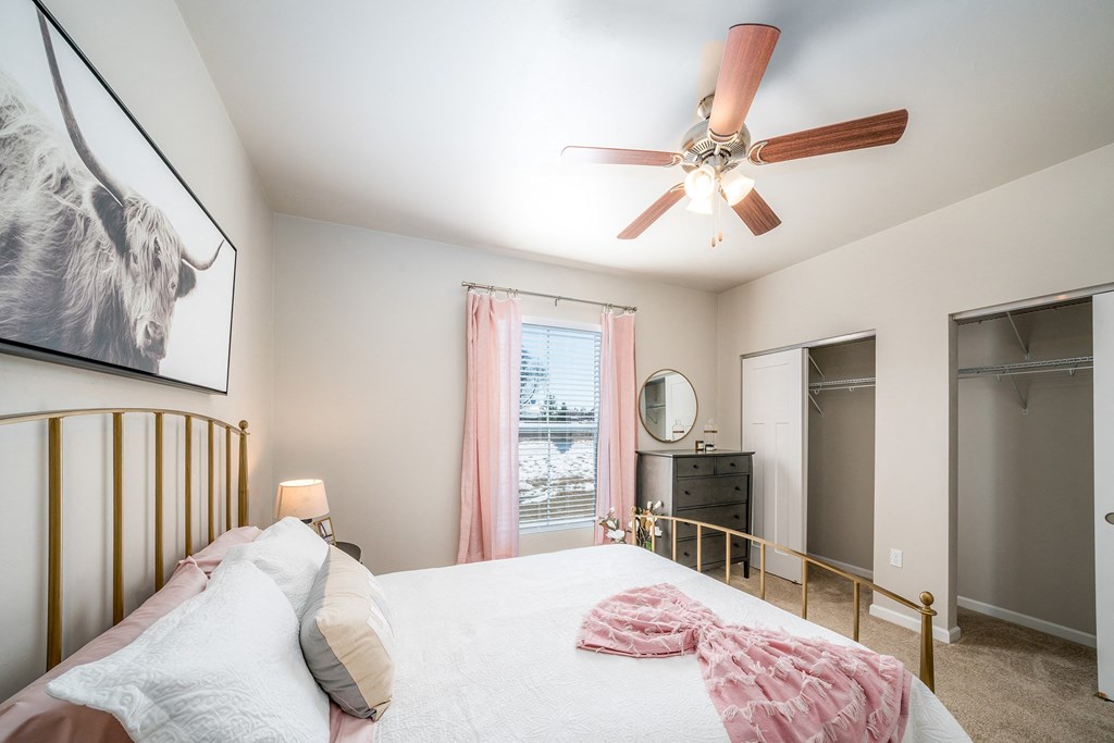 a bedroom with a large bed and a ceiling fan