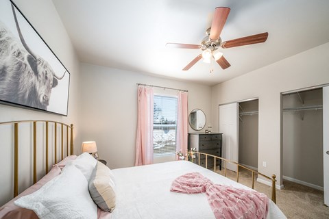 a bedroom with a large bed and a ceiling fan
