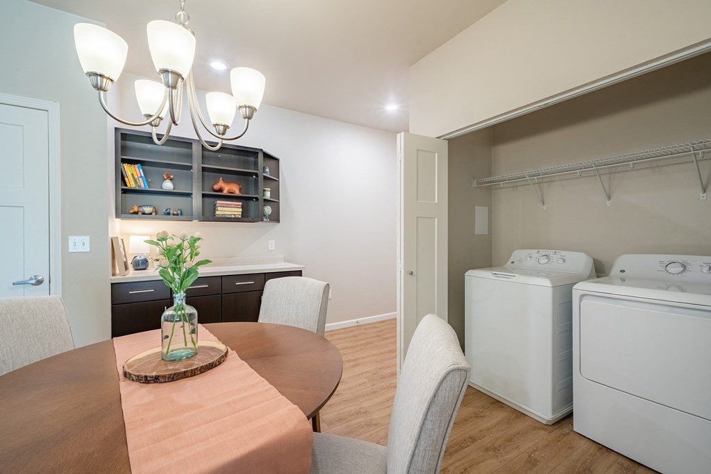 a kitchen and dining room with a washer and dryer and a dining table