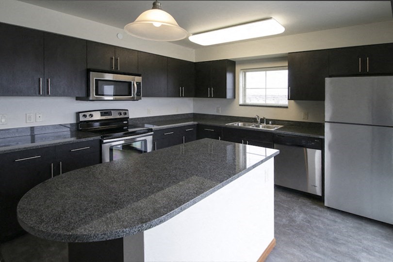 an empty kitchen with granite counter tops and stainless steel appliances