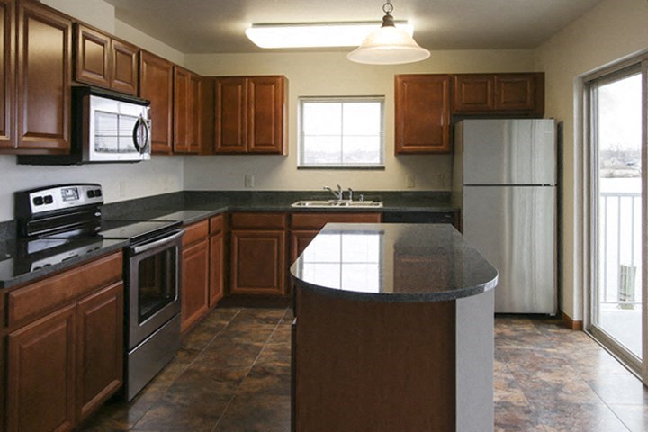 a kitchen with wooden cabinets and stainless steel appliances