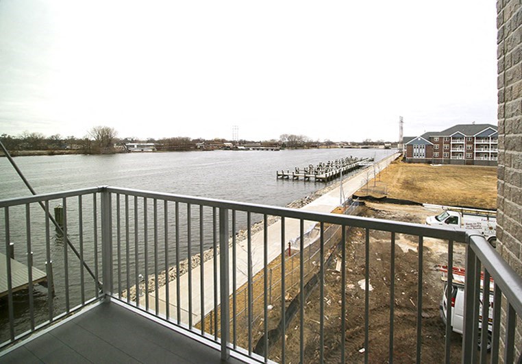 a balcony with a view of a river and some houses