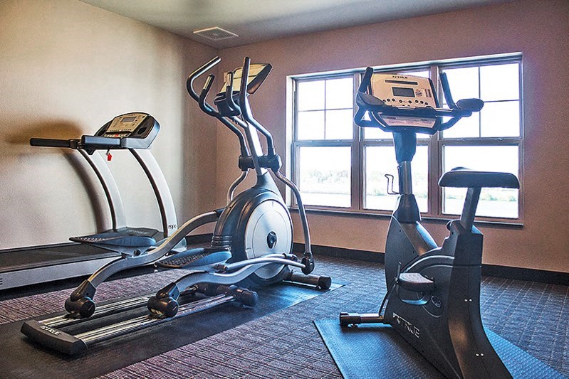 two exercise machines in an empty gym room