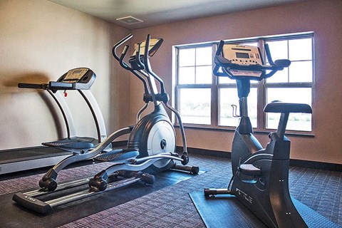 two exercise machines in an empty gym room