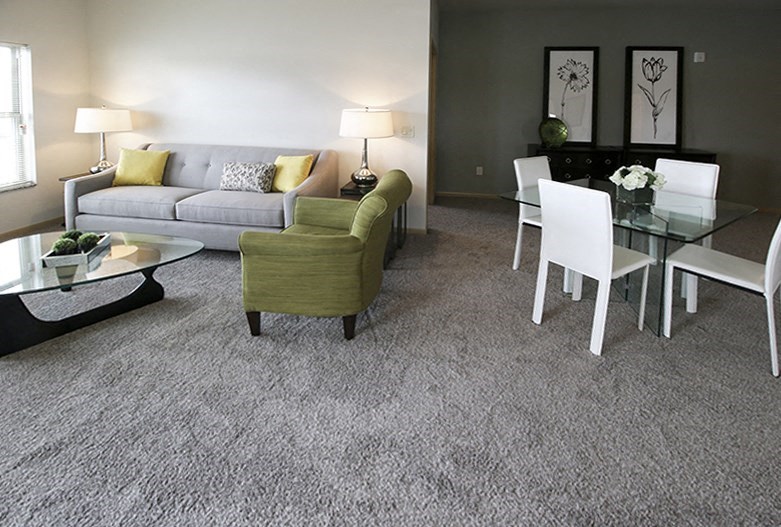 a living room and dining room with a couch and a glass table