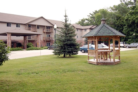 a gazebo in the middle of a yard with a building in the