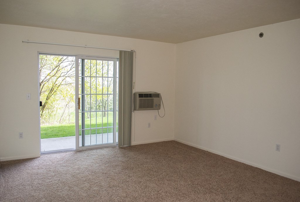 an empty living room with a door to a yard