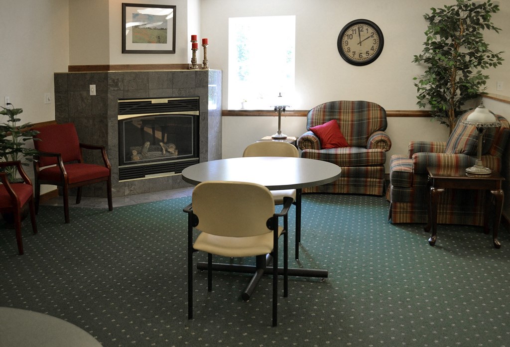 a living room with a fireplace and a table and chairs