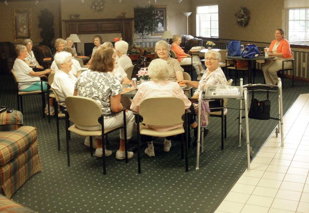 a group of elderly women sitting at tables in a room