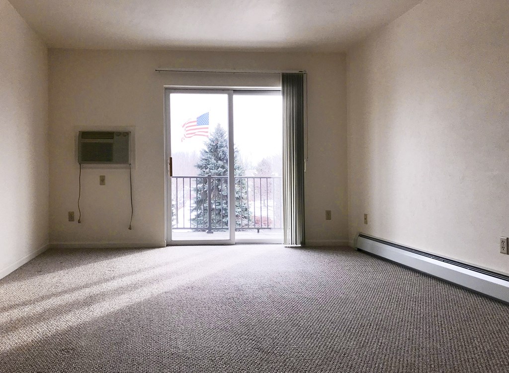 an empty living room with a balcony and an flag