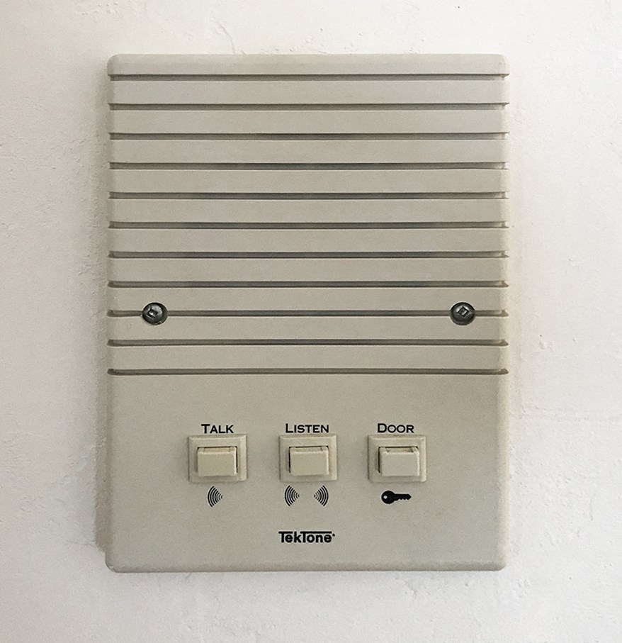 a close up of an external light switch on a white wall