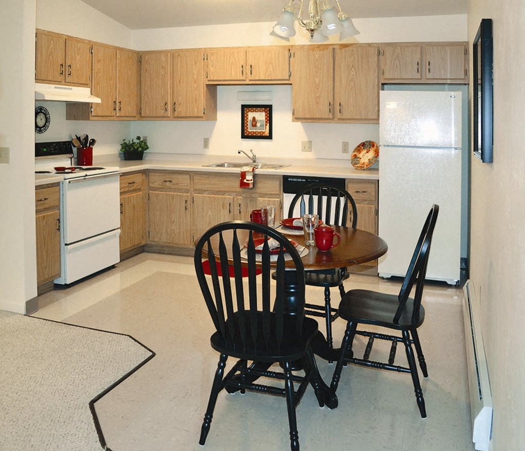 a kitchen with a table and chairs and a refrigerator
