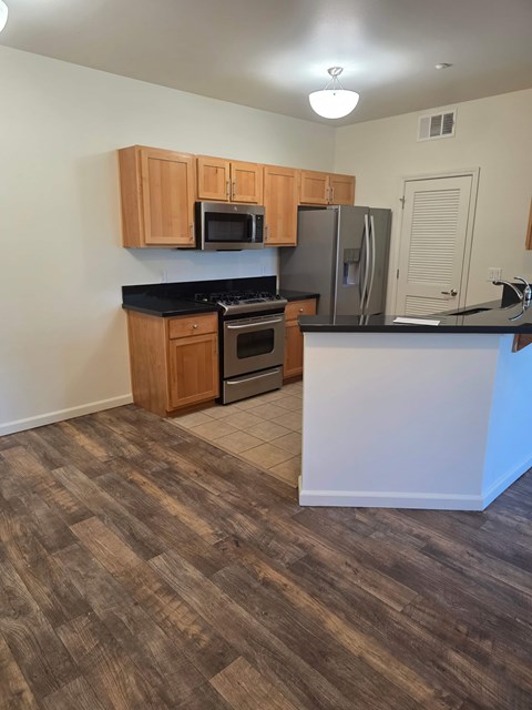 A kitchen with wooden cabinets and a black countertop.