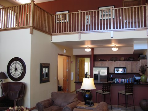 A living room with a couch, chair, and a clock on the wall.