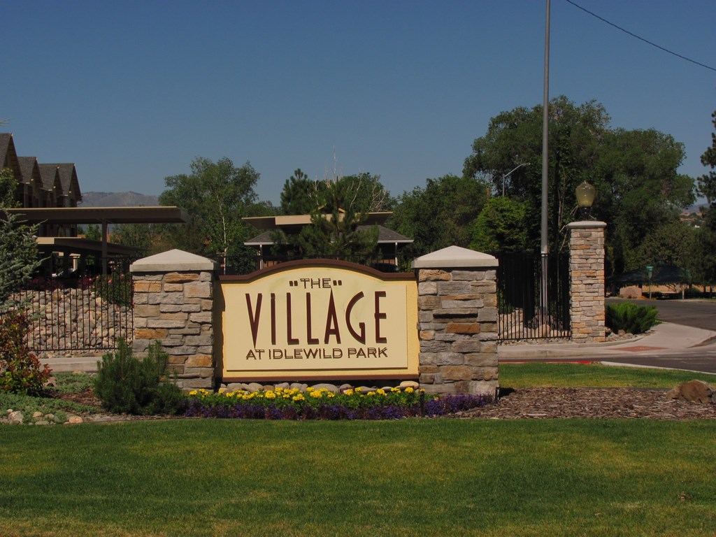 A sign that says "The Village at Idlewild Park" is in front of a building.