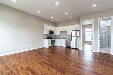 an empty kitchen with white cabinets and a stainless steel refrigerator