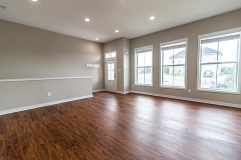 an empty living room with wood floors and windows