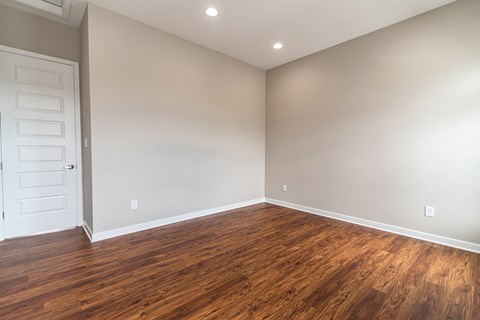 an empty room with wood flooring and a white door