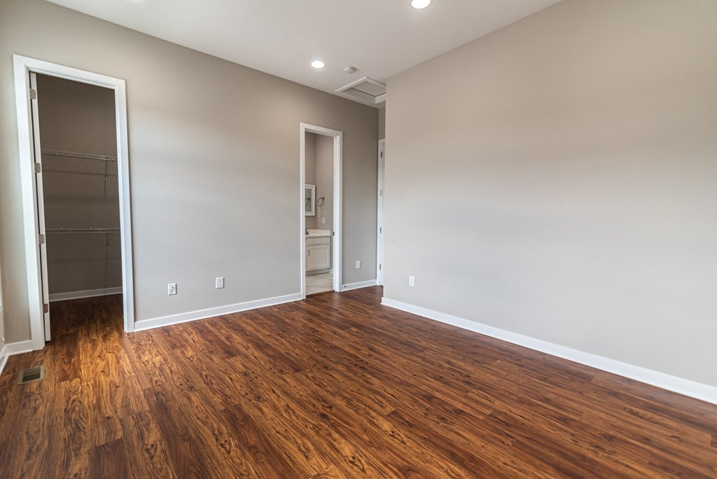 an empty living room with wood flooring and a closet