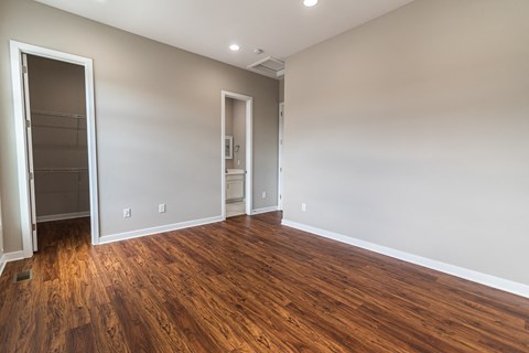 an empty living room with wood flooring and a closet
