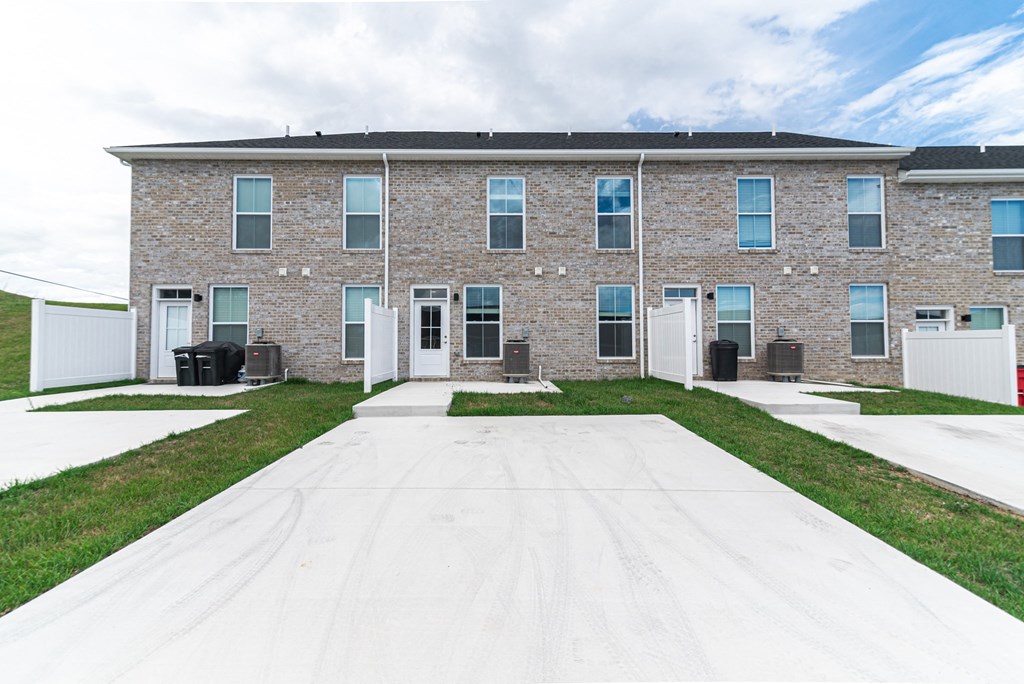 a large brick building with white doors and grass