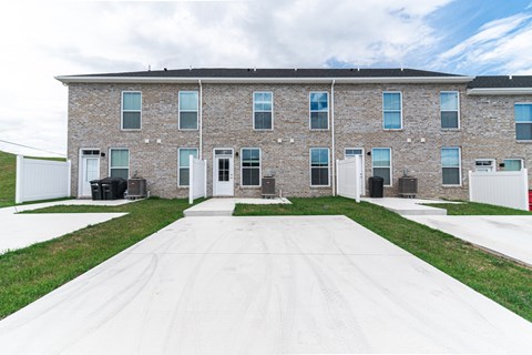 a large brick building with white doors and grass