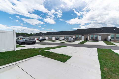 a row of houses with cars parked in a parking lot