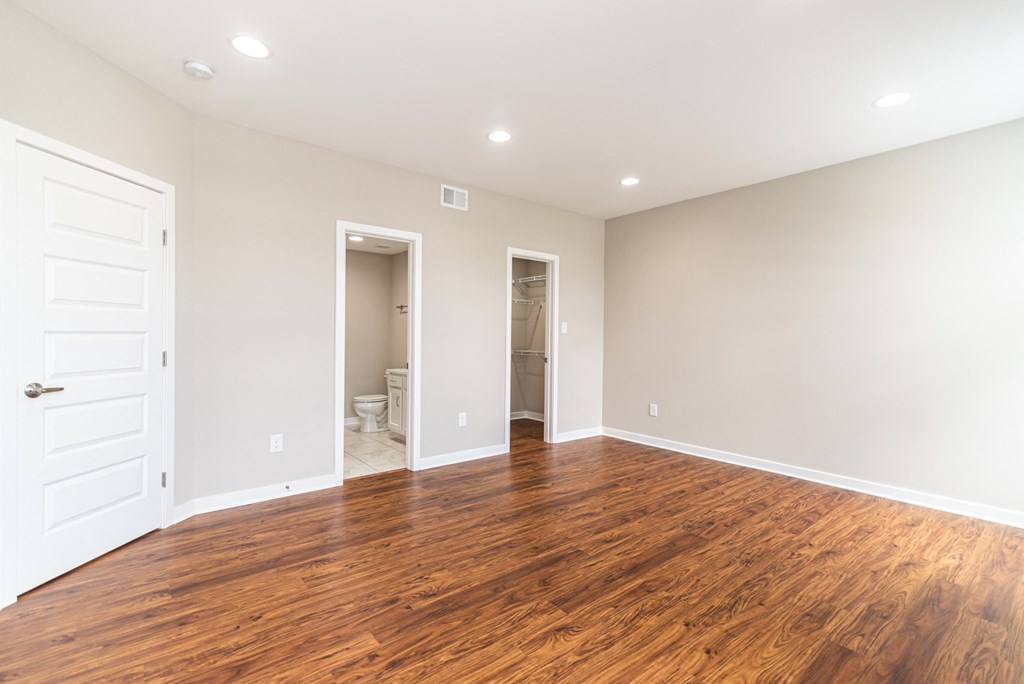 a living room with a hard wood floor and a white door