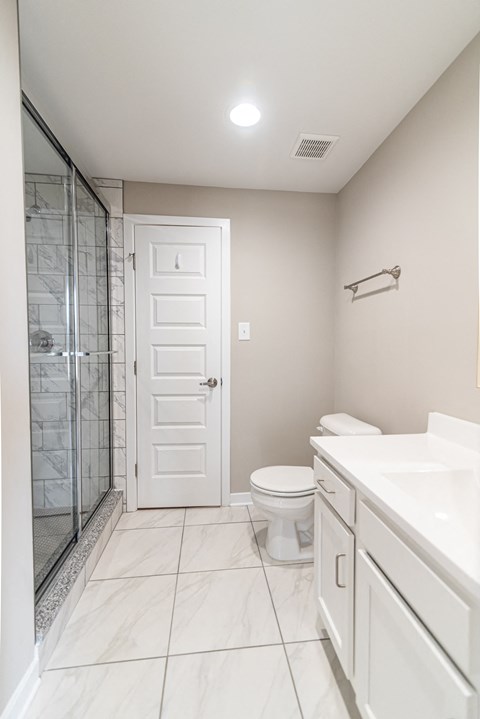 a white bathroom with a shower toilet and sink