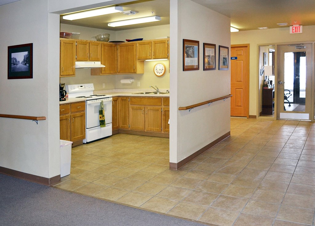 A kitchen with wooden cabinets and a white stove top oven.