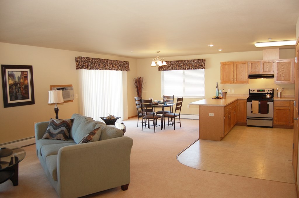 A living room with a couch, chairs, and a dining table.