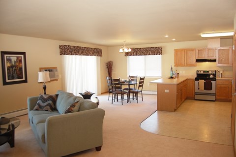 A living room with a couch, chairs, and a dining table.