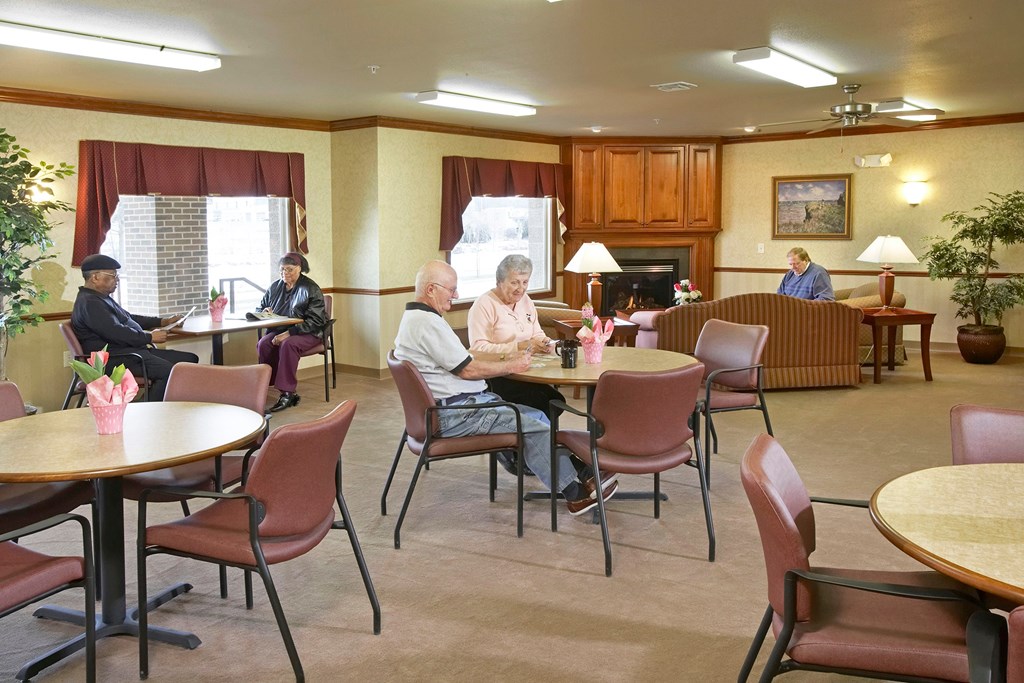 A group of people are sitting around tables in a room.
