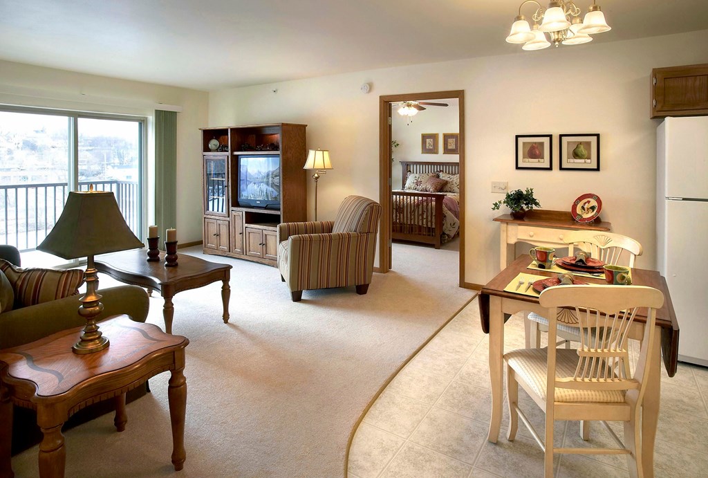 A living room with a couch, chair, and a dining table.