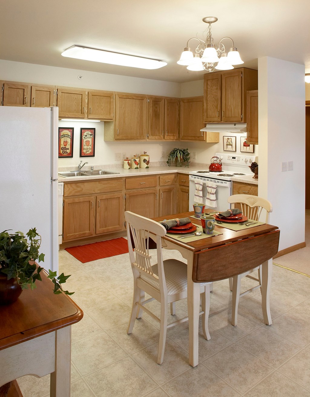 A kitchen with a table and chairs set for two.
