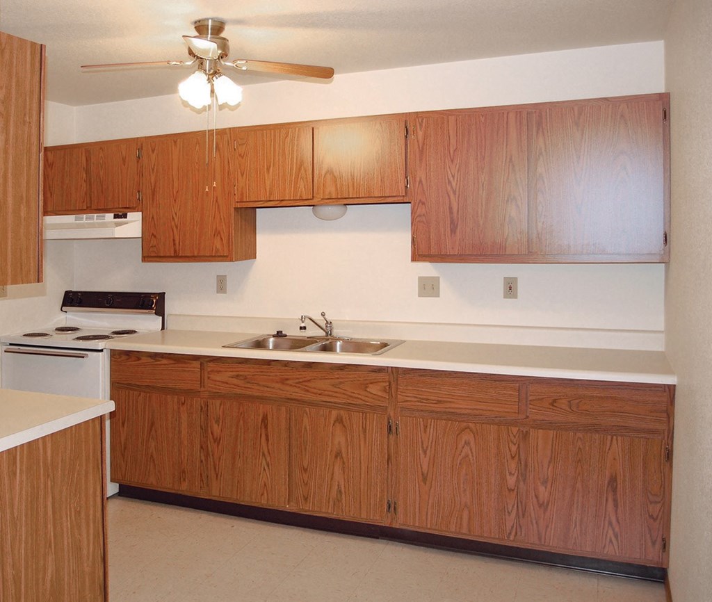 an empty kitchen with wooden cabinets and a sink