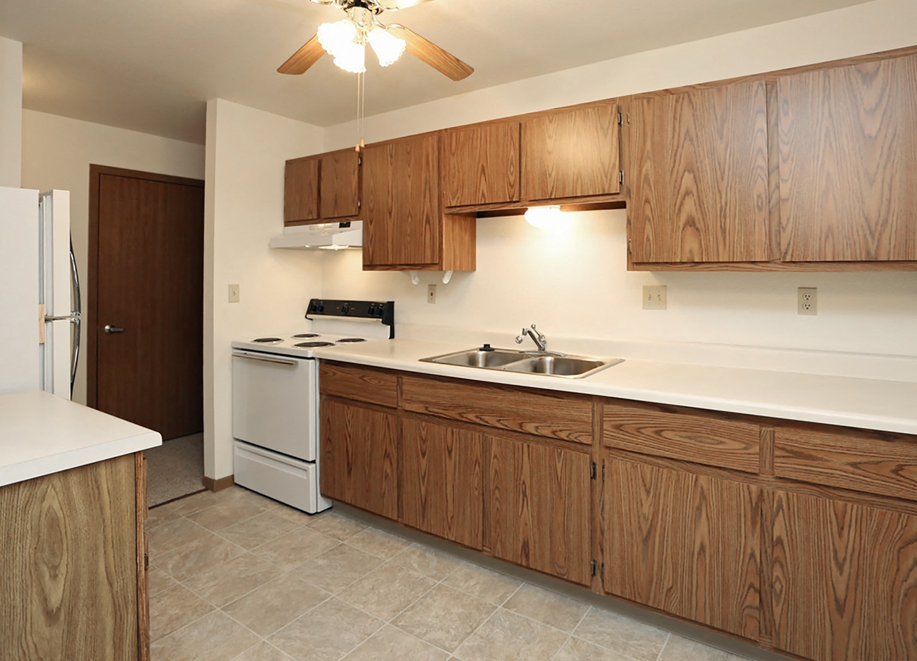 a kitchen with white appliances and wooden cabinets