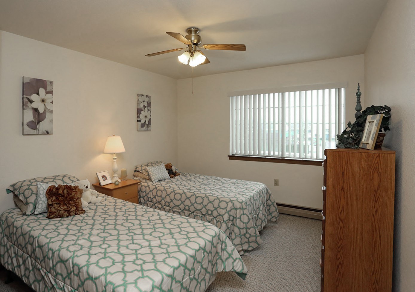 a bedroom with two beds and a ceiling fan
