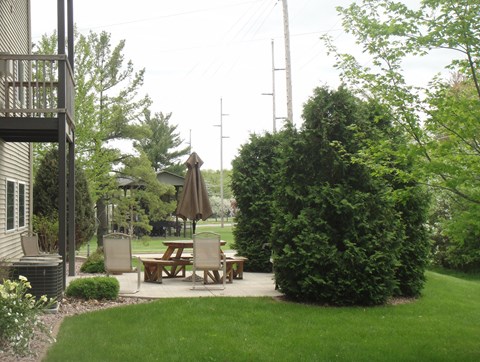 a patio with a table and chairs in a backyard