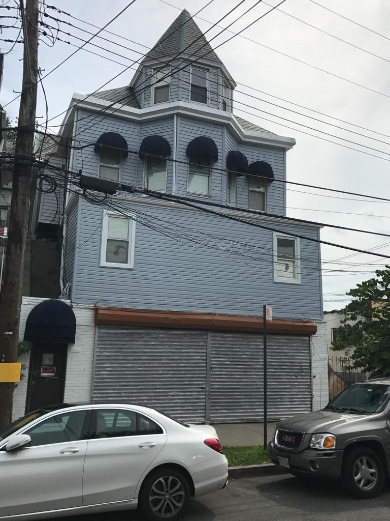 a white car parked in front of a blue building