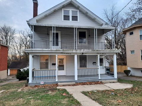 a white house with a porch and a sidewalk