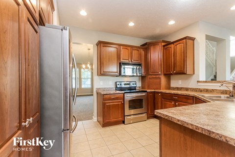 A kitchen with wooden cabinets and a refrigerator.