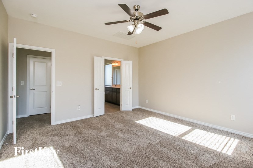 a living room with carpet and a ceiling fan