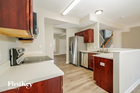 A kitchen with wooden cabinets and a stainless steel refrigerator.