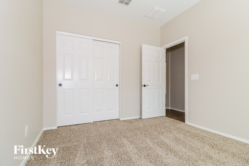 a bedroom with two white doors and a carpeted floor