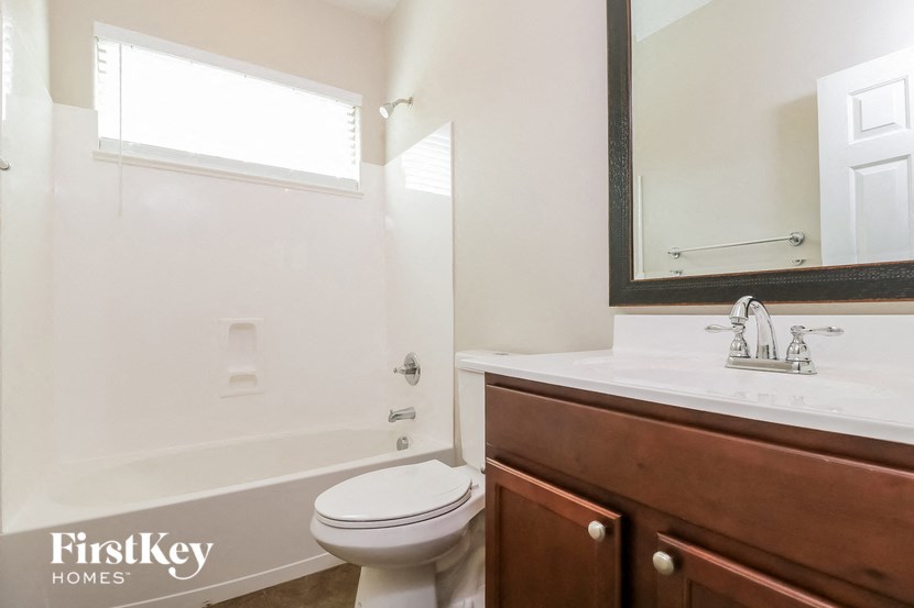 a bathroom with a toilet and a sink and a mirror
