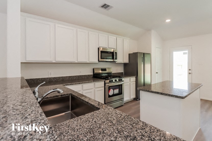 a kitchen with granite counter tops and white cabinets