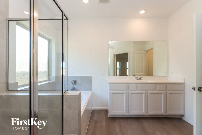 a bathroom with a shower and a sink and a bath tub