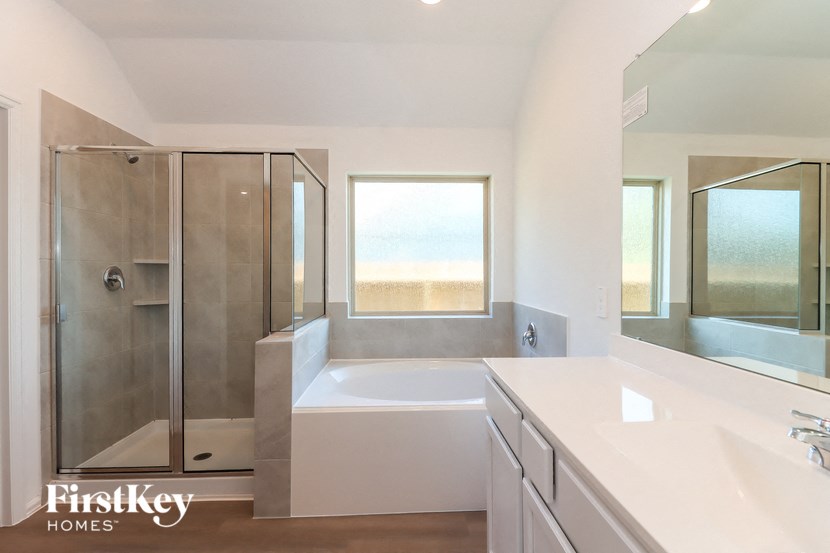 a bathroom with a tub and a shower and a sink